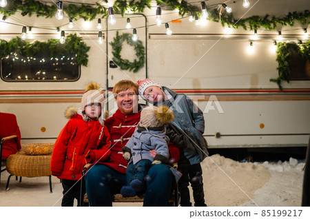 Caucasian man and three sons celebrate Christmas in a mobile home. Caucasian man and three sons celebrate Christmas in a mobile home. 85199217