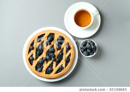 Concept of delicious breakfast with blueberry pie on gray background Concept of delicious breakfast with blueberry pie on gray background 85199665