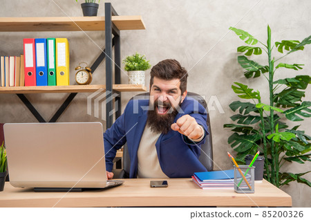 Shaking fist at somebody. Angry boss yelling at office desk. Work stress. Between anger and stress Shaking fist at somebody. Angry boss yelling at office desk. Work stress. Between anger and stress 85200326