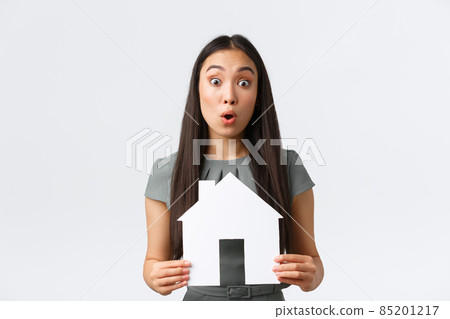 Insurance, loan, real estate and family concept. Surprised asian woman in dress, holding paper house in hands react to big announcement, found excellent apartment for cheap price, white background Insurance, loan, real estate and family concept. Surprised asian woman in dress, holding paper house in hands react to big announcement, found excellent apartment for cheap price, white background 85201217