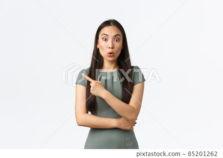 Small business owners, women entrepreneurs concept. Impressed attractive asian woman in dress asking question, looking amazed after seeing something cool, pointing finger left Small business owners, women entrepreneurs concept. Impressed attractive asian woman in dress asking question, looking amazed after seeing something cool, pointing finger left 85201262