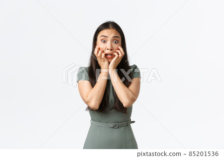 Small business owners, women entrepreneurs concept. Terrified asian woman in dress looking in panic, shivering and stare scared at horrible scene, standing alarmed over white background Small business owners, women entrepreneurs concept. Terrified asian woman in dress looking in panic, shivering and stare scared at horrible scene, standing alarmed over white background 85201536