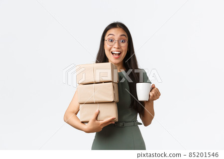 Excited smiling asian female drinking coffee and carry piles of boxes for shipping to clients, small business owner manage customer purchases and packing it, give items to courier, white background Excited smiling asian female drinking coffee and carry piles of boxes for shipping to clients, small business owner manage customer purchases and packing it, give items to courier, white background 85201546