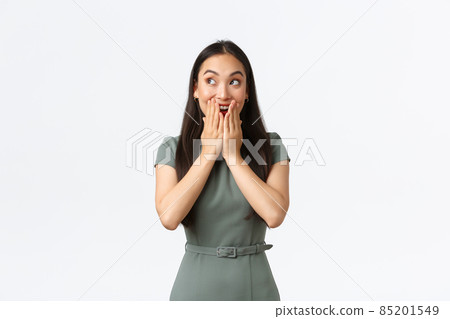 Small business owners, women entrepreneurs concept. Excited and happy pleased asian woman in dress looking upper left corner astonished with amazing news, react to surprise or awesome promo 85201549