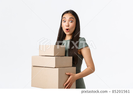 Small business owners, startup and work from home concept. Surprised and amazed asian girl collect her shopping items in post office. Astonished businesswoman carry orders to delivery company Small business owners, startup and work from home concept. Surprised and amazed asian girl collect her shopping items in post office. Astonished businesswoman carry orders to delivery company 85201561