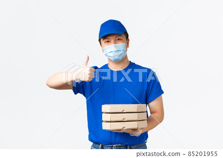 Contactless delivery, covid-19 shipping, preventing virus concept. Smiling asian courier in blue uniform, medical mask and gloves provide safe and fast delivery, show thumbs-up, handing pizza boxes Contactless delivery, covid-19 shipping, preventing virus concept. Smiling asian courier in blue uniform, medical mask and gloves provide safe and fast delivery, show thumbs-up, handing pizza boxes 85201955