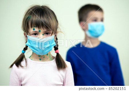 Boy and girl wearing blue protective medical mask ill with chickenpox, measles or rubella virus with rashes on body. Children protection during epidemic of coronovirus. Covid-19 contagion concept. Boy and girl wearing blue protective medical mask ill with chickenpox, measles or rubella virus with rashes on body. Children protection during epidemic of coronovirus. Covid-19 contagion concept. 85202151