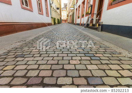 Beautiful view of scenic narrow street with historic traditional houses and cobbled street in an old town in Europe with blue sky and clouds in summer Beautiful view of scenic narrow street with historic traditional houses and cobbled street in an old town in Europe with blue sky and clouds in summer 85202213