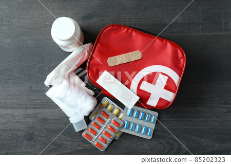 First aid medical kit on dark wooden background First aid medical kit on dark wooden background 85202323