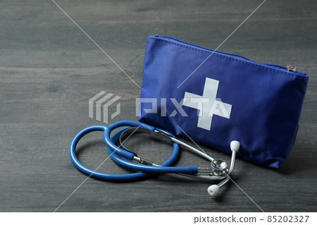 First aid medical kit on dark wooden background 85202327
