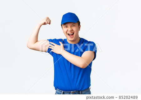 Sassy smiling asian courier in blue uniform, flex biceps confident. Delivery man express confidence, showing how strong his arms, carry heavy clients parcels, standing white background Sassy smiling asian courier in blue uniform, flex biceps confident. Delivery man express confidence, showing how strong his arms, carry heavy clients parcels, standing white background 85202489