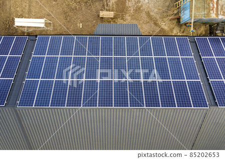 Aerial top view of new modern residential house cottage with blue shiny solar photo voltaic panels system on roof. Renewable ecological green energy production concept. 85202653