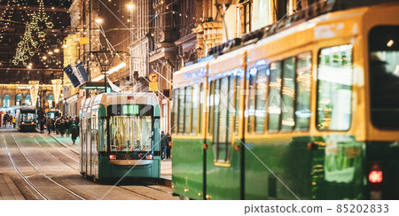 Helsinki, Finland. Tram Departs From Stop On Aleksanterinkatu Street. Night Evening Christmas Xmas New Year Festive Illumination On Street. Beautiful Street Decorations During Winter Holidays 85202833