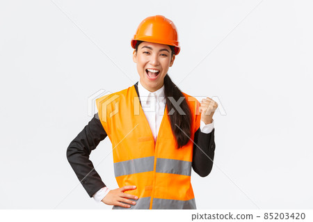 Successful businesswoman, construction manager in safety helmet, fist pump and say yes. Female asian architect celebrating great news, achieve goal at building zone, white background 85203420