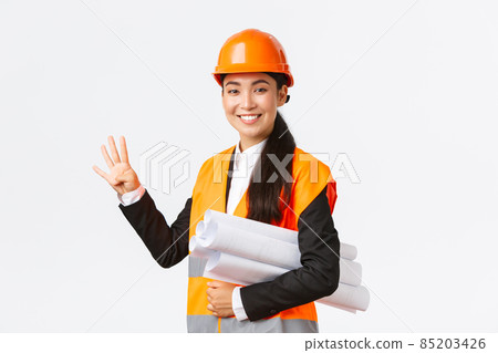 Smiling confident asian female engineer, construction manager in safety helmet, carry blueprints, showing four fingers, ensure building finished in time, standing white background upbeat 85203426