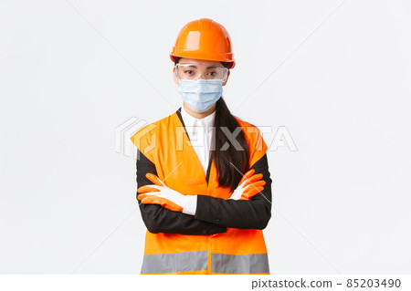 Covid-19 safety protocol at enterpise, construction and preventing virus concept. Confident asian female chief engineer looking how workers follow protocol during coronavirus, wear face mask Covid-19 safety protocol at enterpise, construction and preventing virus concept. Confident asian female chief engineer looking how workers follow protocol during coronavirus, wear face mask 85203490