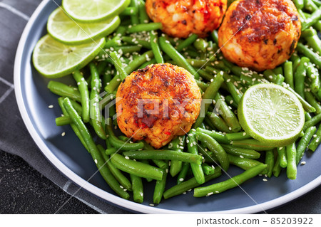 Prawn and Crab Cakes on a plate with green beans Prawn and Crab Cakes on a plate with green beans 85203922