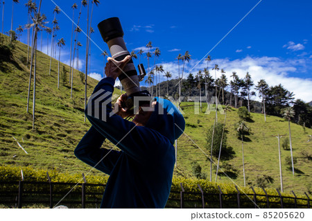 Tourist taking pictures at the beautiful Valle de Cocora located in Salento at the Quindio region in Colombia 85205620