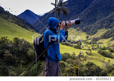 Tourist taking pictures at the beautiful Valle de Cocora located in Salento at the Quindio region in Colombia 85205621