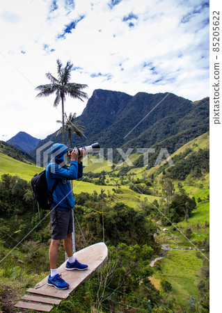 Tourist taking pictures at the beautiful Valle de Cocora located in Salento at the Quindio region in Colombia 85205622