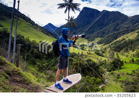 Tourist taking pictures at the beautiful Valle de Cocora located in Salento at the Quindio region in Colombia 85205623