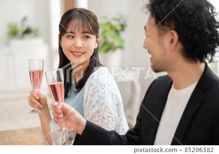 A couple of young beautiful men and women having a very fun date at a home party 1 up 85206382