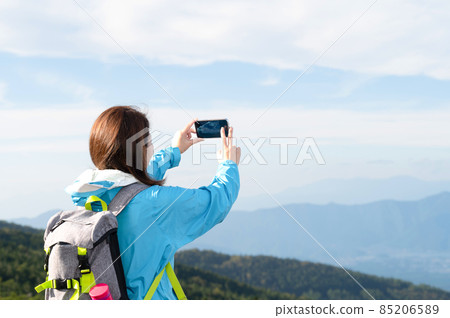Japanese women taking pictures of smartphones at the summit after climbing There is a copy space Japanese women taking pictures of smartphones at the summit after climbing There is a copy space 85206589