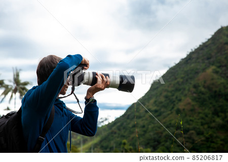 Tourist taking pictures at the beautiful Valle de Cocora located in Salento at the Quindio region in Colombia 85206817