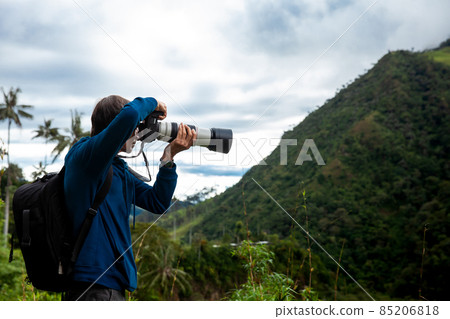 Tourist taking pictures at the beautiful Valle de Cocora located in Salento at the Quindio region in Colombia 85206818