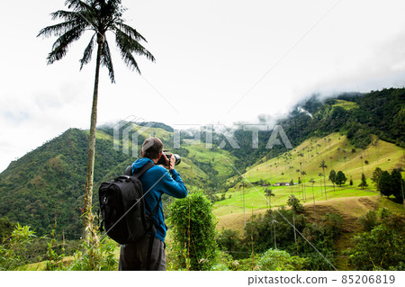 Tourist taking pictures at the beautiful Valle de Cocora located in Salento at the Quindio region in Colombia 85206819