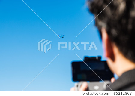 A man steering drone A man steering drone 85211868