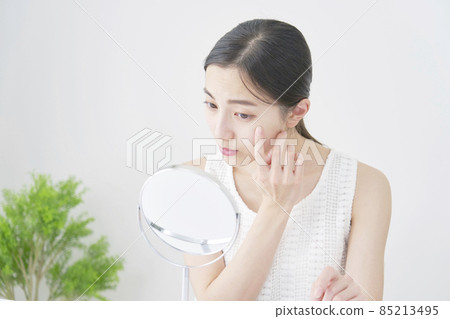 Woman looking at mirror 85213495