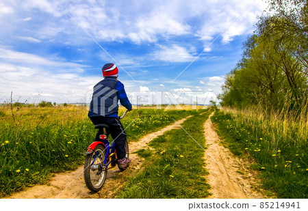 Boy on bike on country road in sunny day 85214941