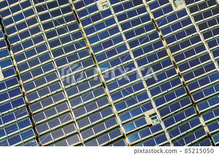 Aerial view of many photo voltaic solar panels mounted of industrial building roof. Aerial view of many photo voltaic solar panels mounted of industrial building roof. 85215050