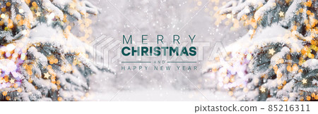 2022 Merry Christmas text blurred background with red xmas balls decoration on branches, bokeh, sparkles. Xmas and New Year greeting card, bokeh, light. 85216311