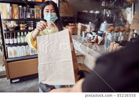 Woman in mask taking order from waitress at cafe Woman in mask taking order from waitress at cafe 85216358