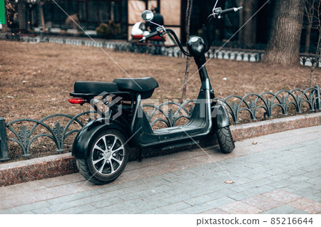 Black electric scooter on the road. Ecological and urban transport in the city Black electric scooter on the road. Ecological and urban transport in the city 85216644