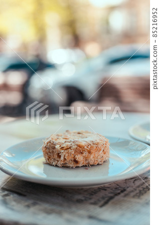 A piece of homemade napoleon cake with cream on a table in a street restaurant. Tasty morning food 85216952