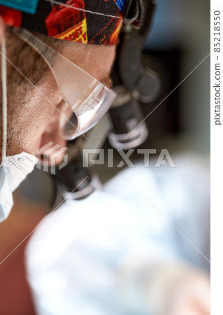 Close-up Shot of the Professional Surgeon Suture Wound during Real Surgery. In the Background Modern Hospital Operation Room. Close-up Shot of the Professional Surgeon Suture Wound during Real Surgery. In the Background Modern Hospital Operation Room. 85218550