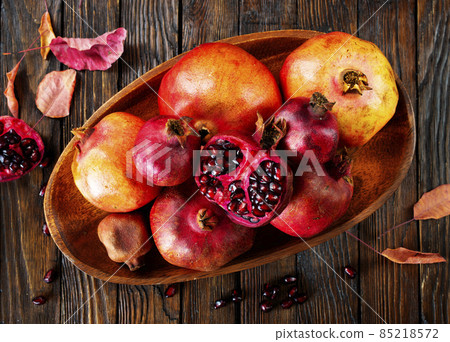 still life with red granates, pomegranates on wooden plate still life with red granates, pomegranates on wooden plate 85218572