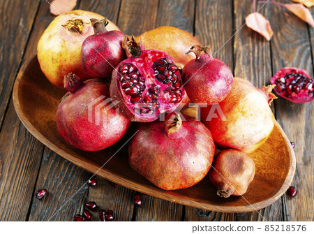 still life with red granates, pomegranates on wooden plate still life with red granates, pomegranates on wooden plate 85218576