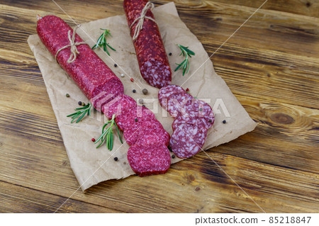 Salami sausages on craft paper on a wooden table Salami sausages on craft paper on a wooden table 85218847