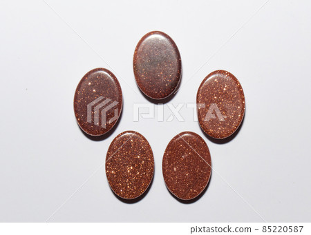 Natural oval cabochon brown aventurine gold on the white background 85220587