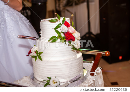 Bride and groom cuting white wedding cake Bride and groom cuting white wedding cake 85220686