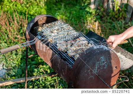 cooking raw meat in a grid on the barbeque grill cooking raw meat in a grid on the barbeque grill 85220741
