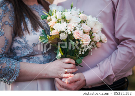 Groom and bride holding colorfull wedding bouquet in the hand Groom and bride holding colorfull wedding bouquet in the hand 85221192