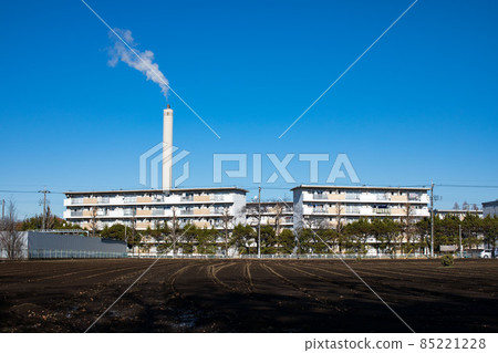 The smoke and blue sky of the chimney of the garbage incinerator over the housing complex in Saiwaicho, Tachikawa-shi, Tokyo 85221228