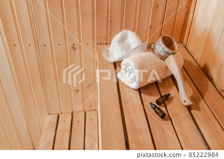 Traditional old Russian bathhouse SPA Concept. Interior details Finnish sauna steam room with traditional sauna accessories set towel aroma oil scoop felt. Relax country village bath concept 85222984