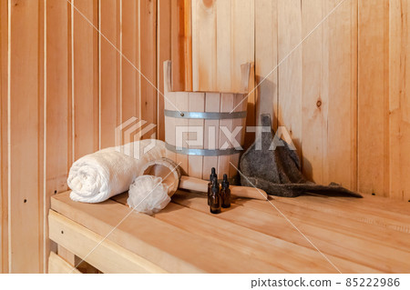 Traditional old Russian bathhouse SPA Concept. Interior details Finnish sauna steam room with traditional sauna accessories set basin towel aroma oil scoop felt. Relax country village bath concept 85222986