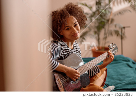 Female musician guitarist playing guitar at home Female musician guitarist playing guitar at home 85223823